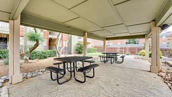 A patio with a table and chairs under a roof.